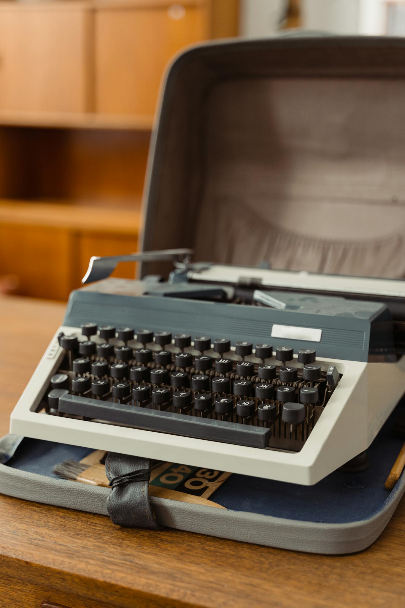 A retro typewriter displayed in a stylish brown wooden case.