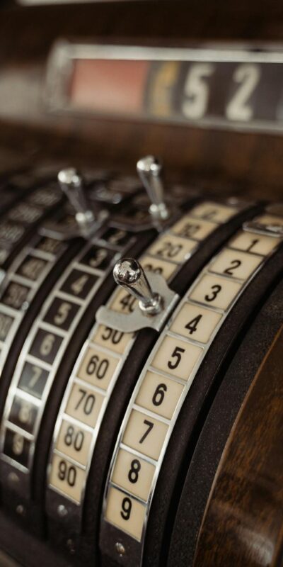 Close-up of a vintage cash register showing mechanical dials and levers.